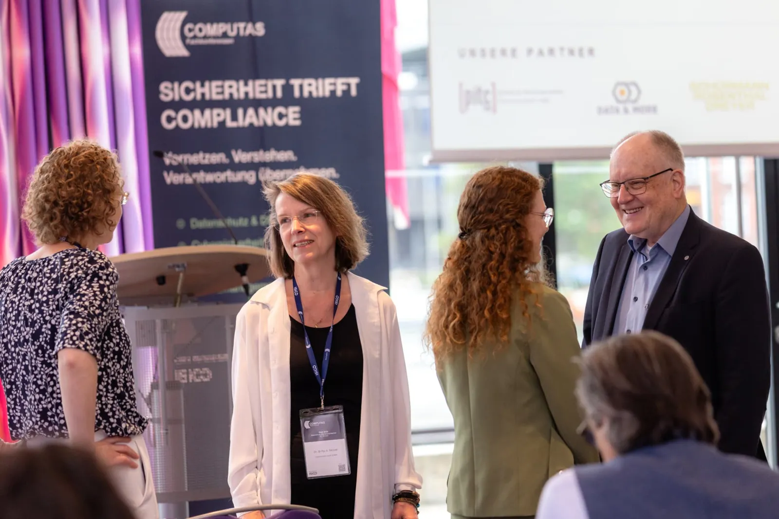 Austausch vor der Partnerwand beim DuD Fachkongress 2026